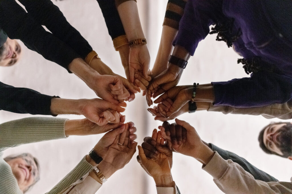 collaboration across ethnicity group hands together
