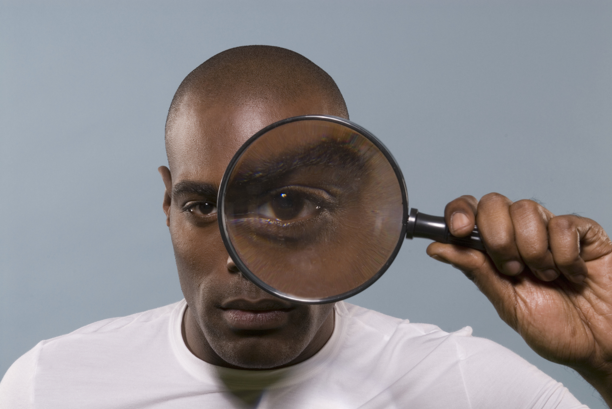 man takes a close look for survey bias through a magnifying glass