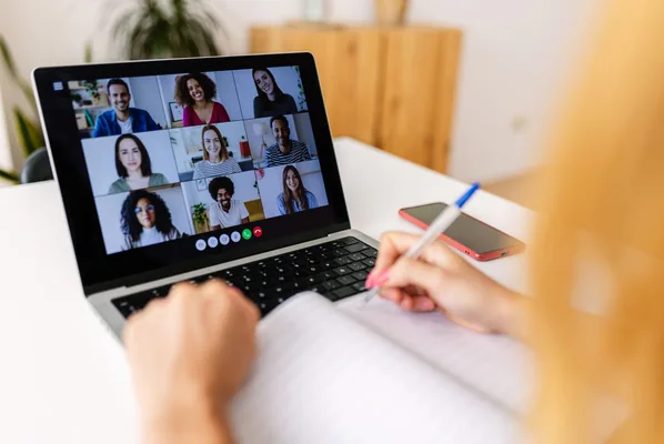A laptop showing a video call with multiple participants